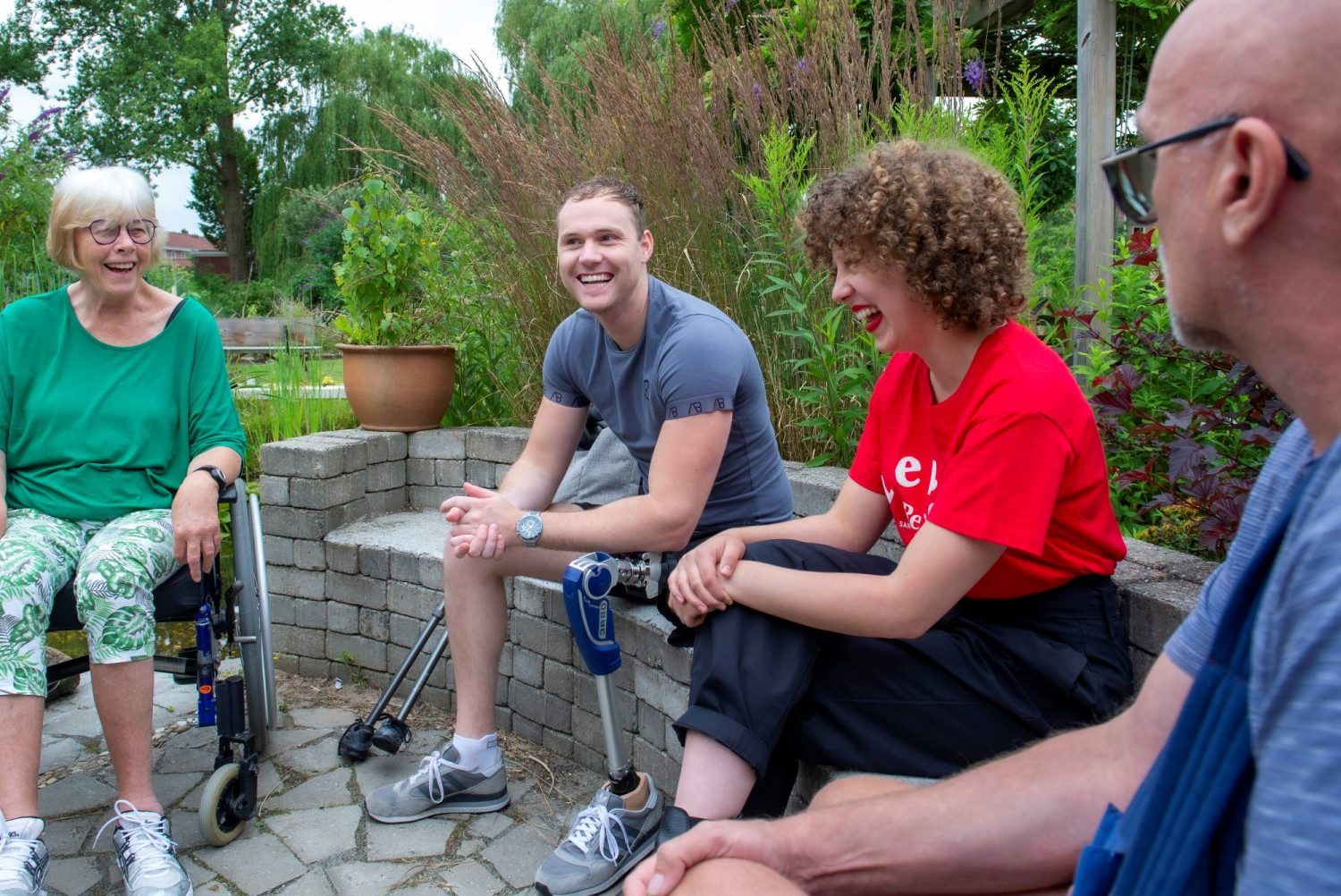 Sven zit met mede revalidanten in de tuin bij Vogellanden