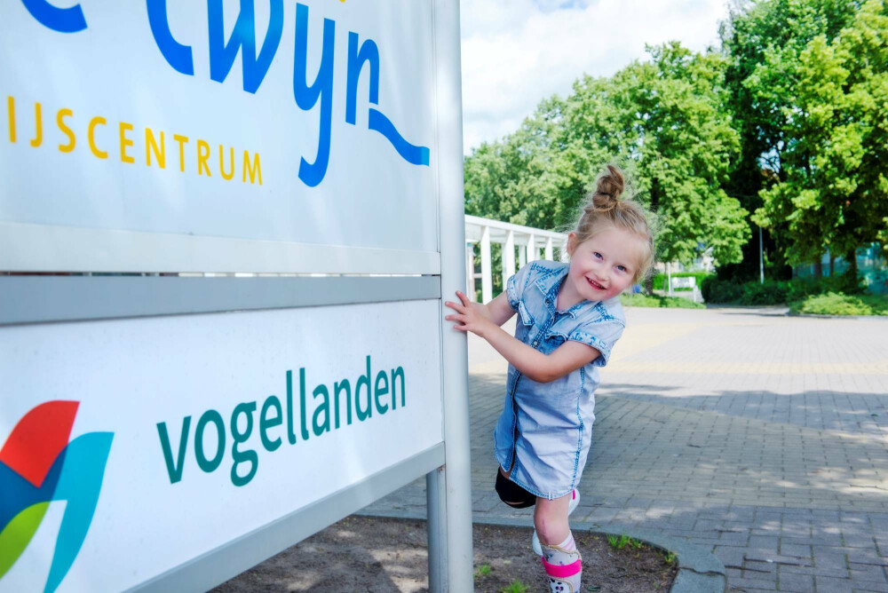 Meisje op schoolplein bij bord Twijn en Vogellanden