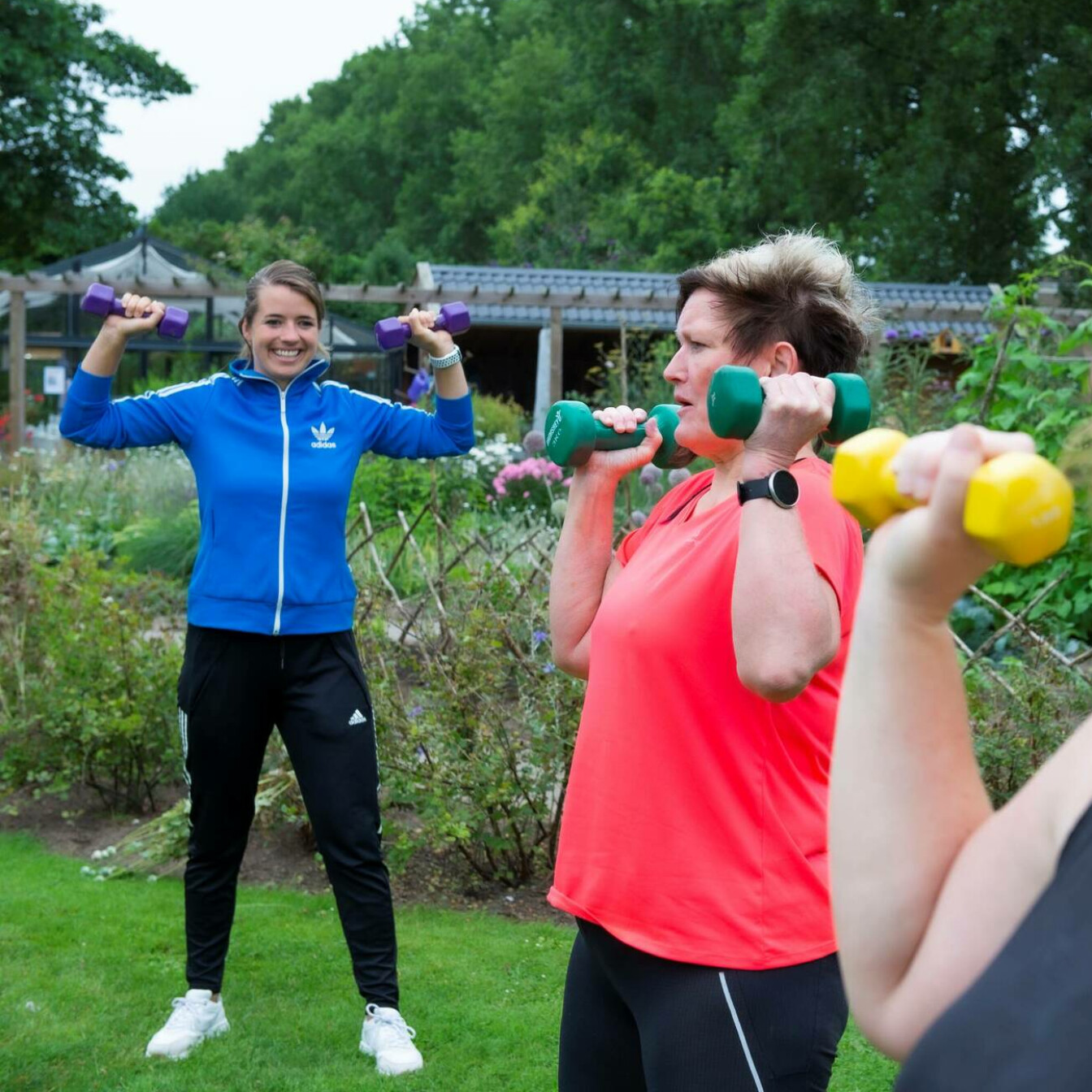 De beweegcoach doet een oefening met gewichten voor