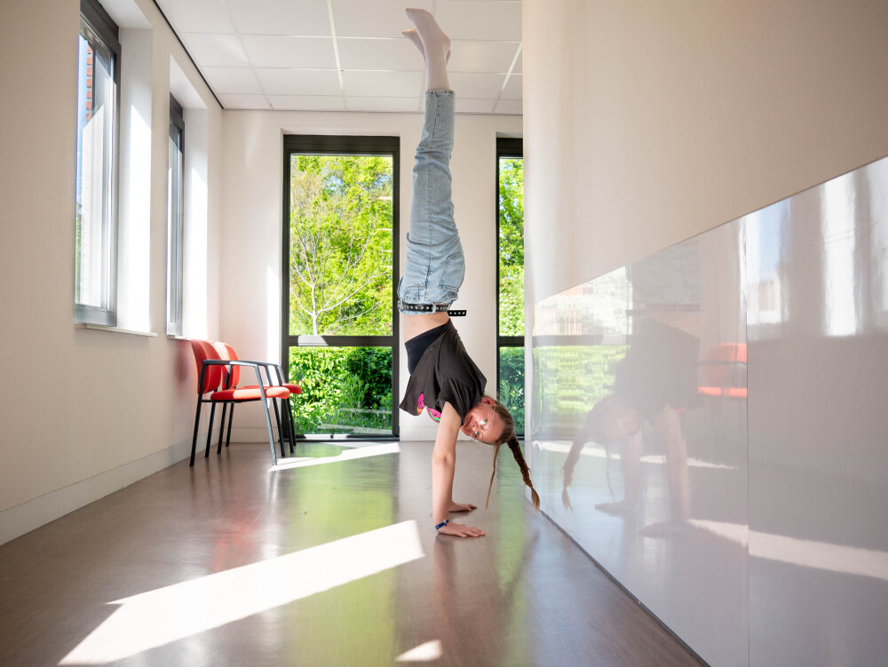 Lynn doet een handstand in de gang van het CBT