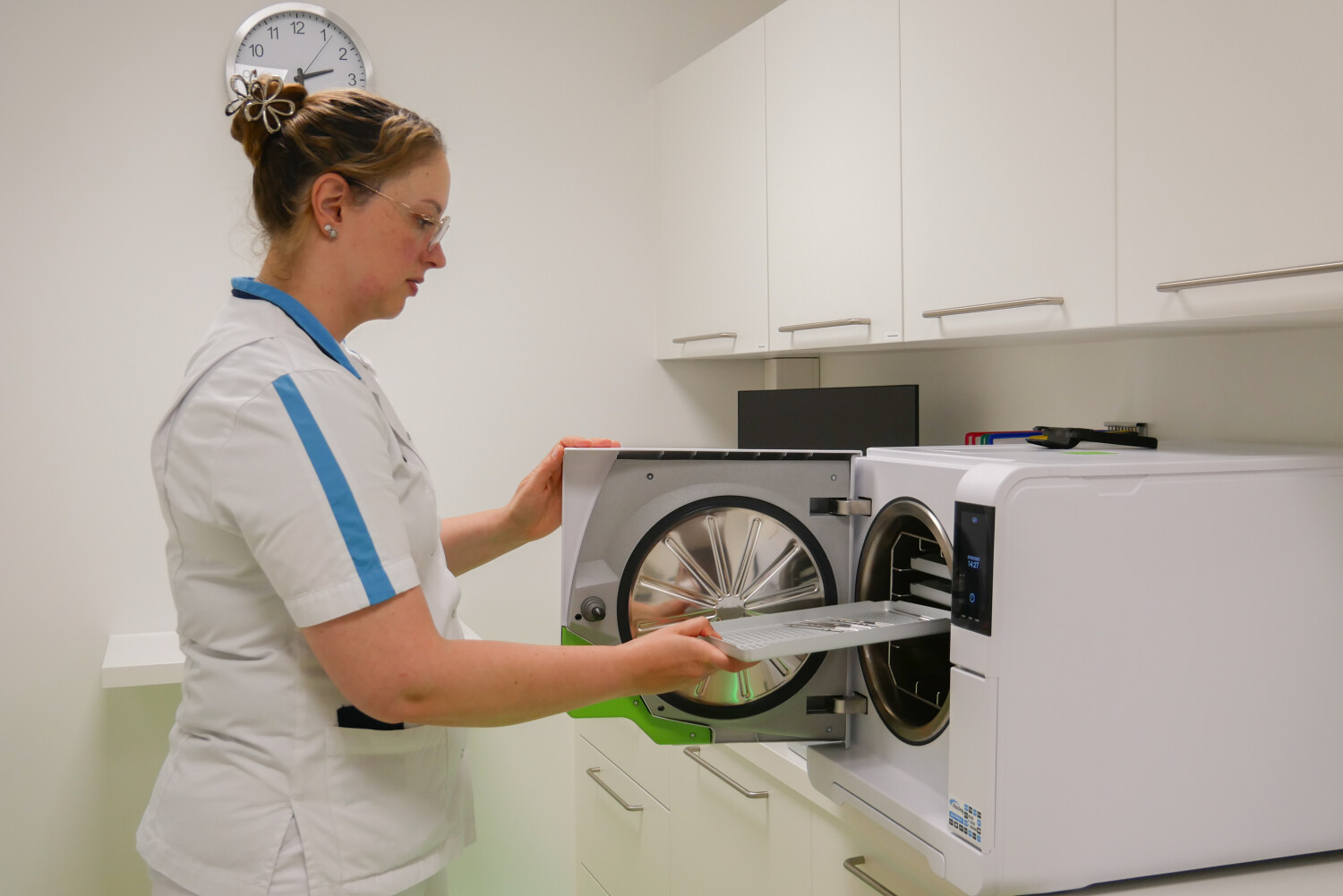 Tandartsassistent maakt gereedschap schoon in apparaat