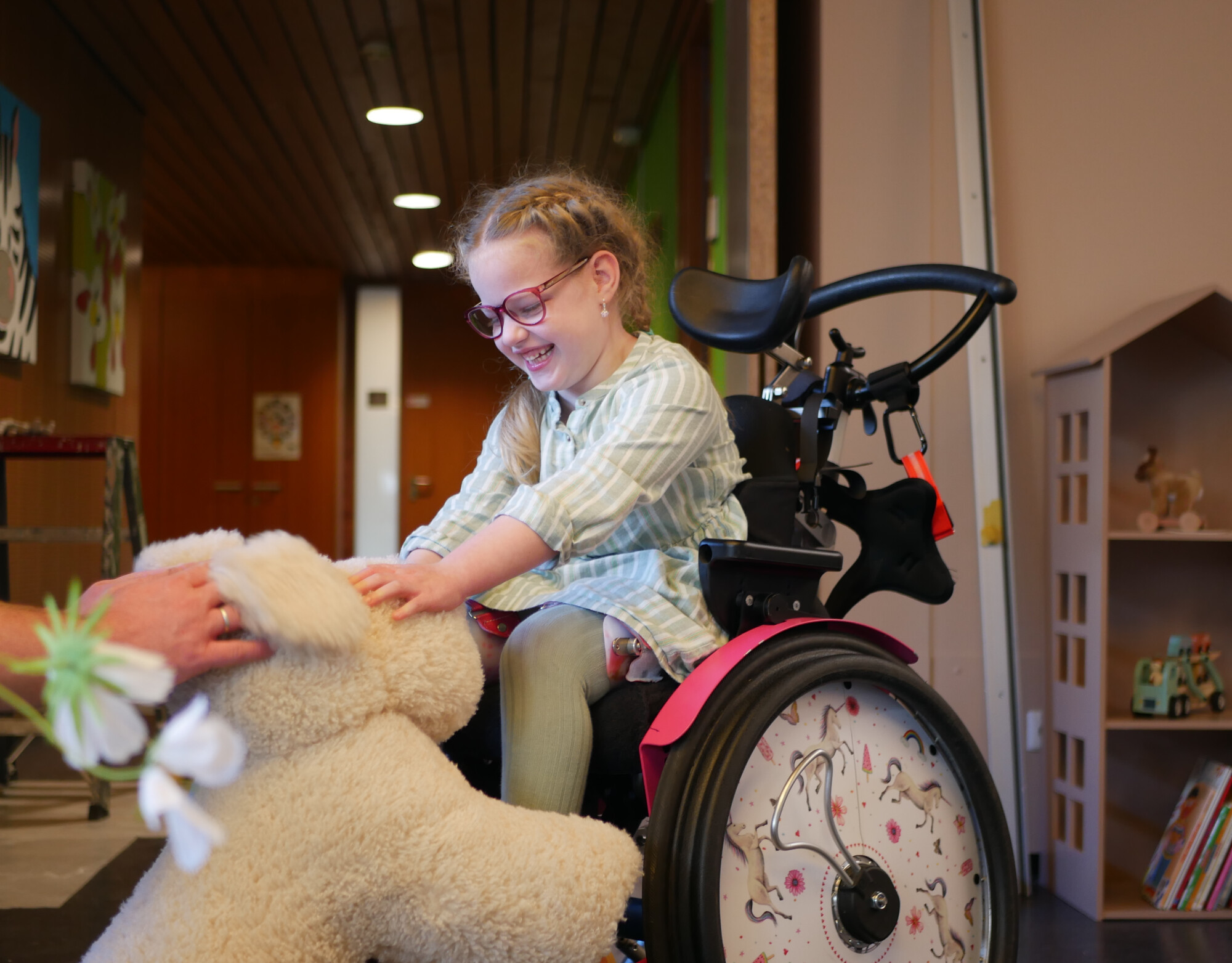 Saar zit in haar rolstoel en aait een grote knuffelhond