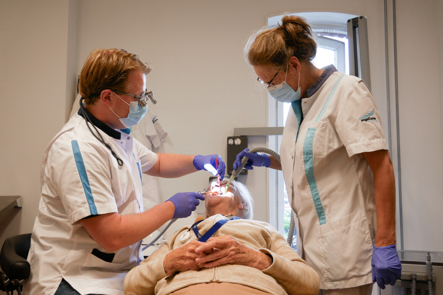 Tandarts en assistent behandelen patiënt