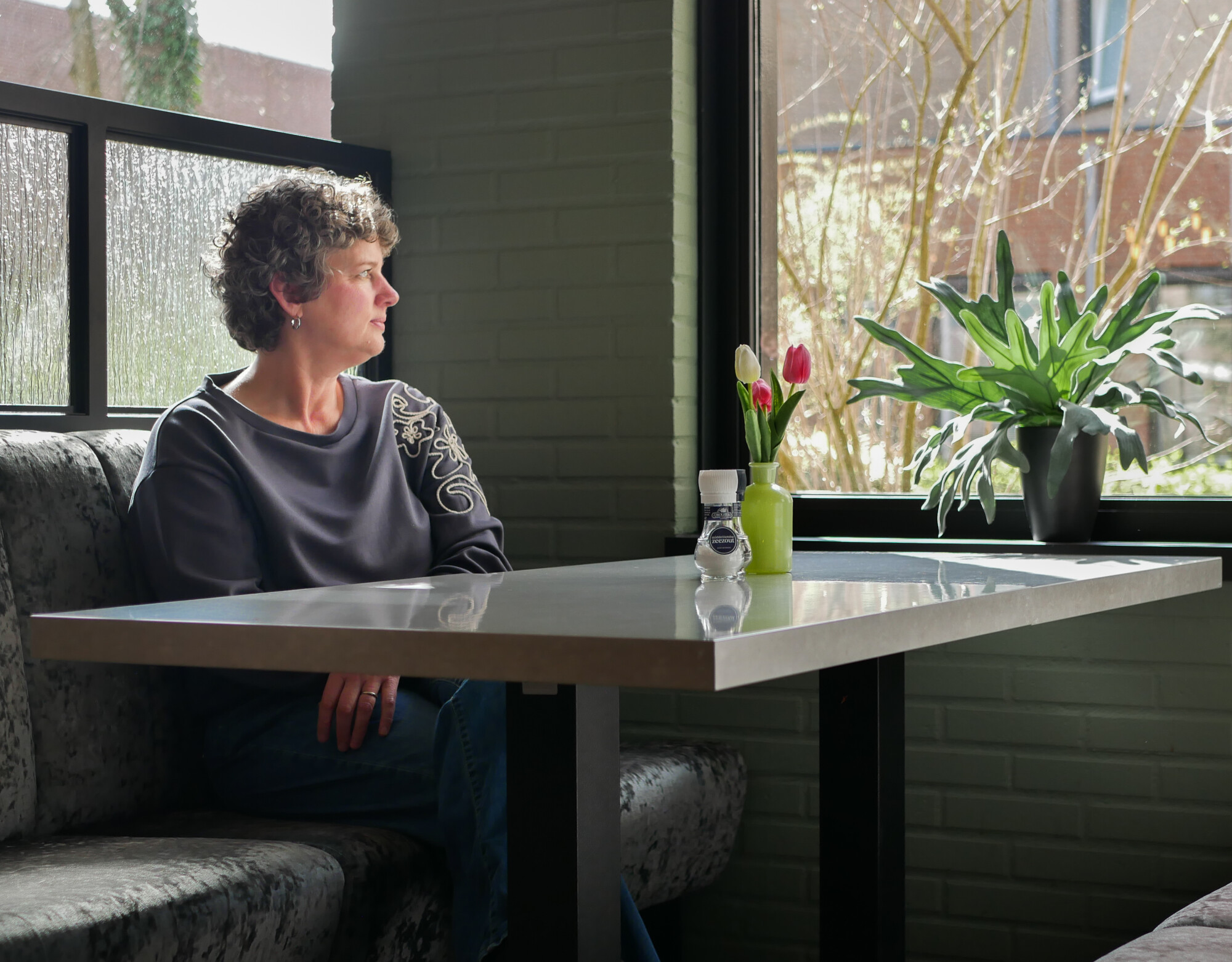 Corine kijkt uit het raam.