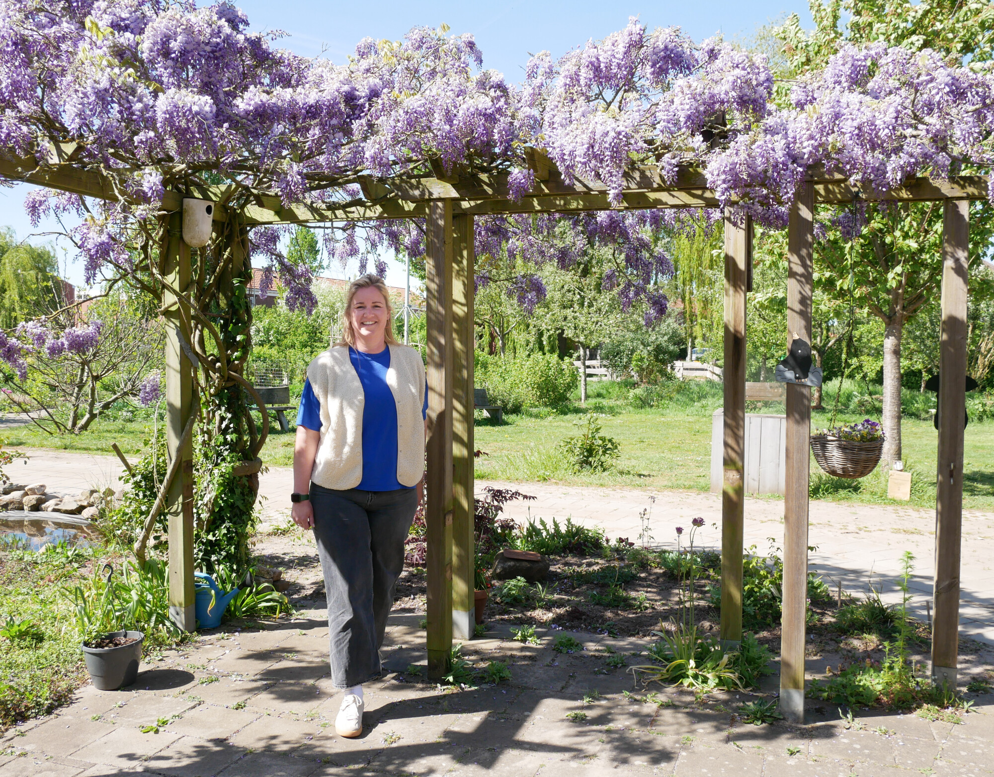 Nienke poseert in de Beleeftuin onder de paarse vlinderbloemen