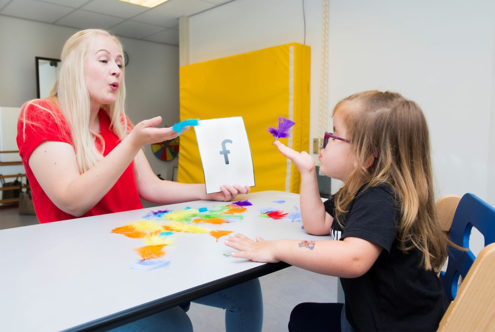 Behandelaar doet oefeningen met kind in school