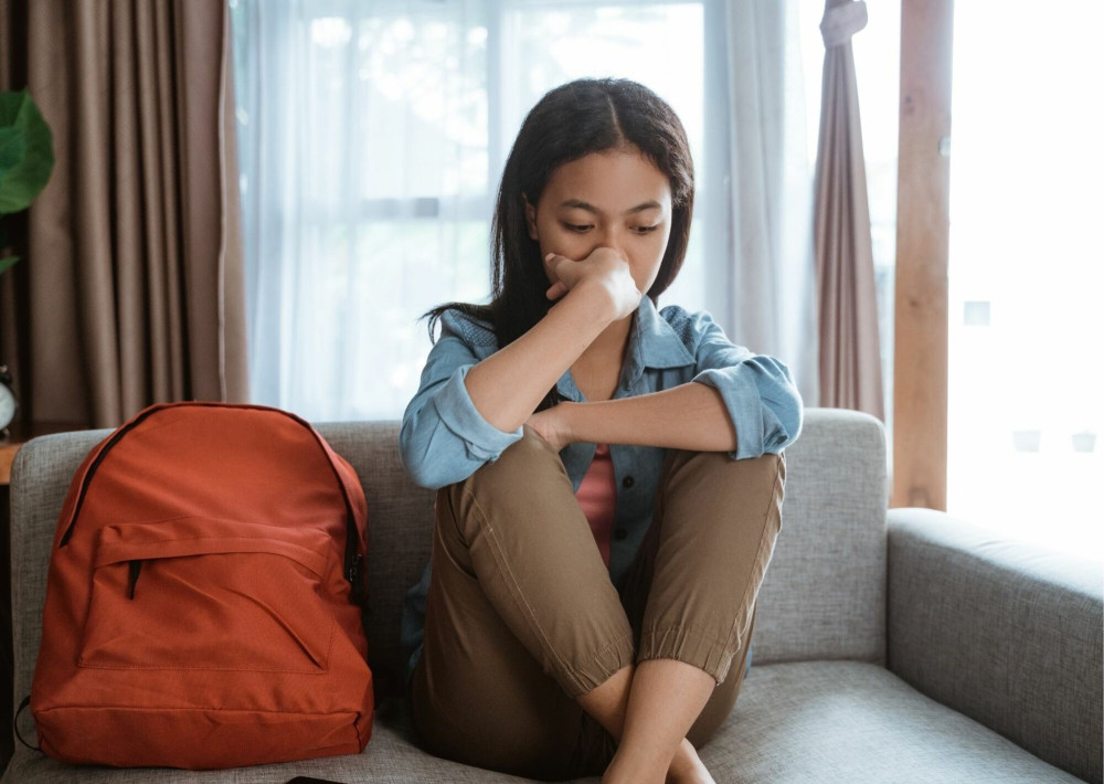 tiener op de bank en denkt na.