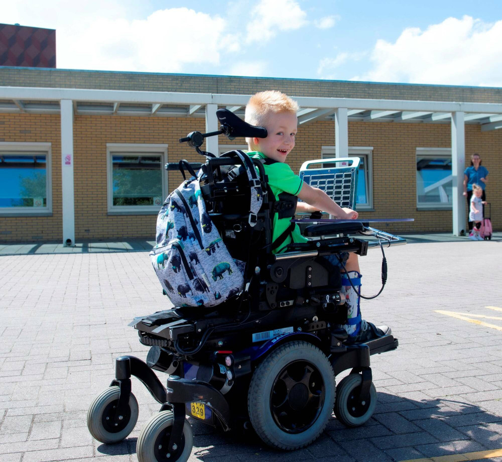 kind in elektrische rolstoel op schoolplein Boterdiep