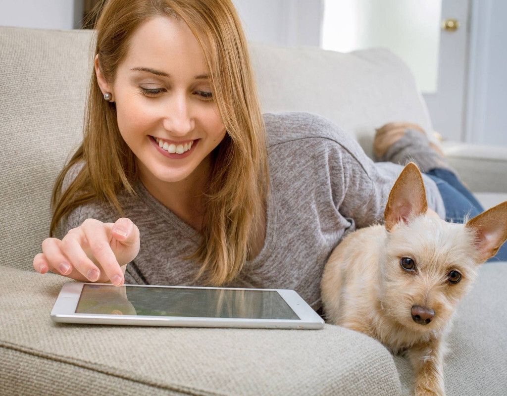 vrouw met tablet en hond op de bank