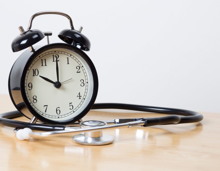 Klok en stethoscoop op een tafel