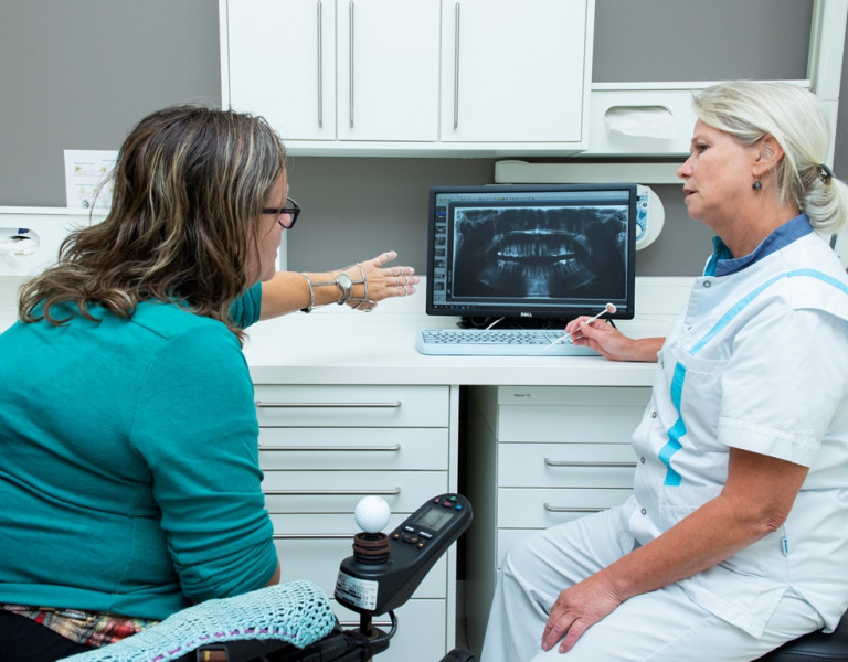 tandarts en patiënt bespreken röntgenfoto van het gebit